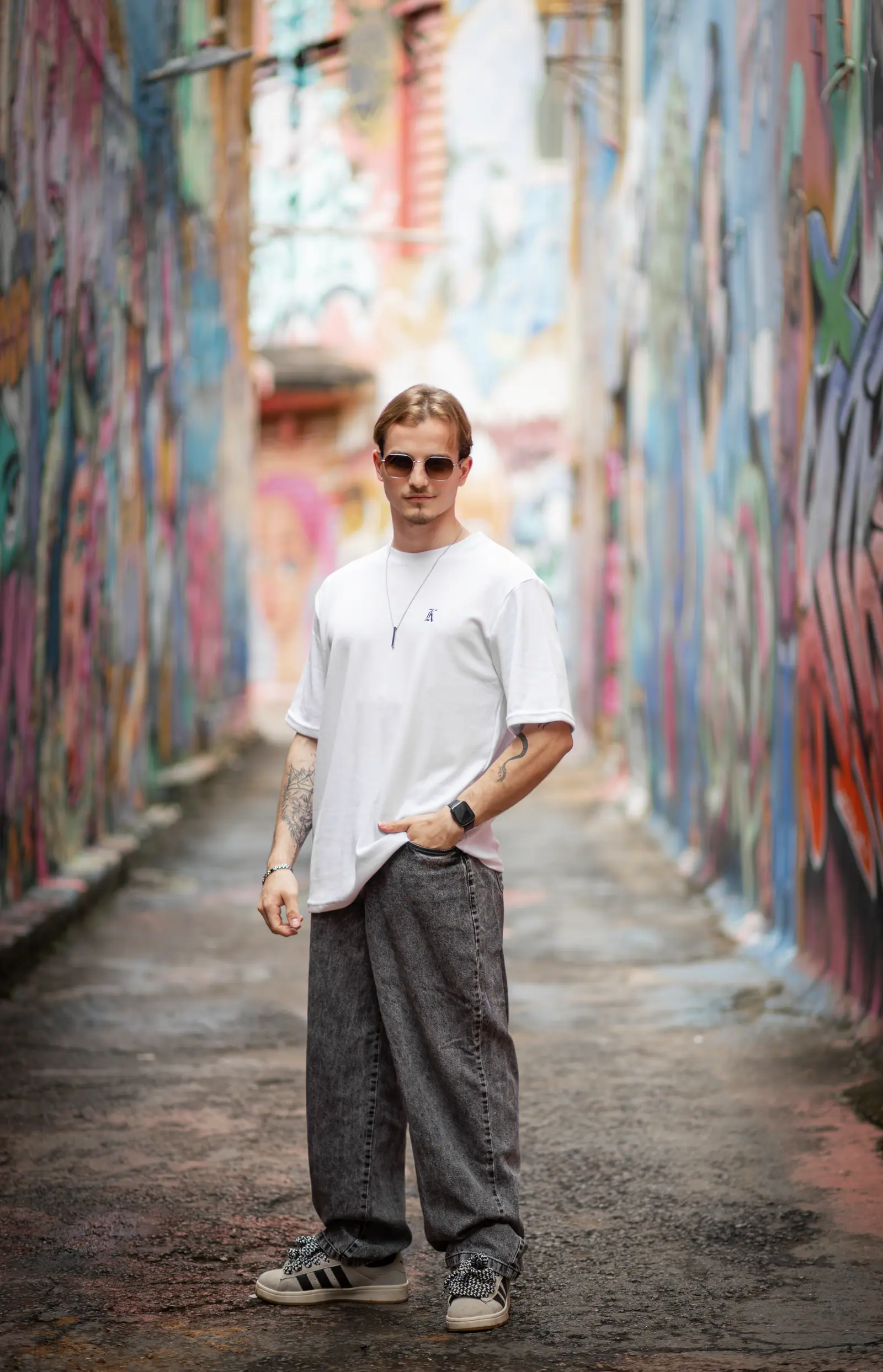 Modelo de camiseta branca da KOUNTING em beco com graffiti colorido